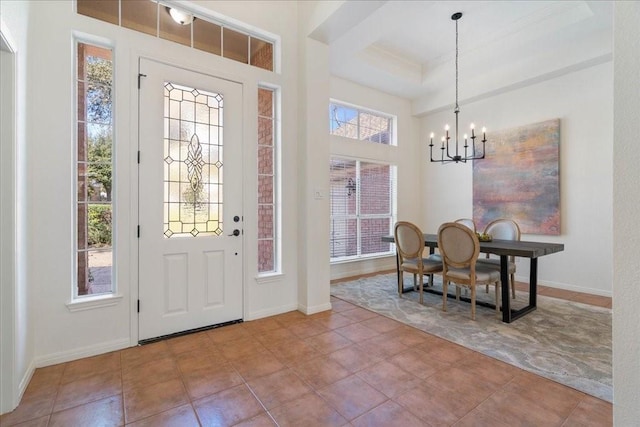 entryway featuring a healthy amount of sunlight, tile patterned flooring, and a notable chandelier