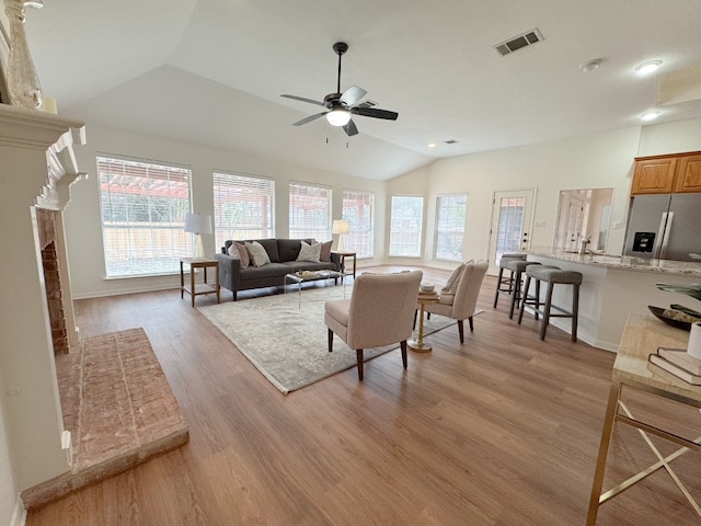 10113 Planters Woods Dr, Austin, TX 78730 - living area with lofted ceiling, healthy amount of natural light, a ceiling fan, light wood-style flooring, and a fireplace