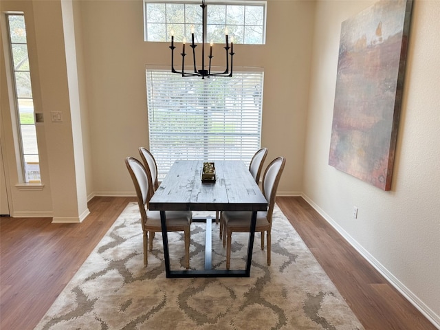 dining area with a chandelier, baseboards, and wood finished floors