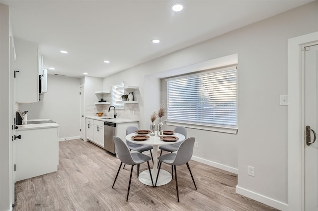 dining area with sink and light hardwood / wood-style flooring