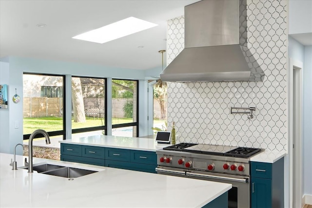 kitchen featuring backsplash, extractor fan, sink, a skylight, and range with two ovens