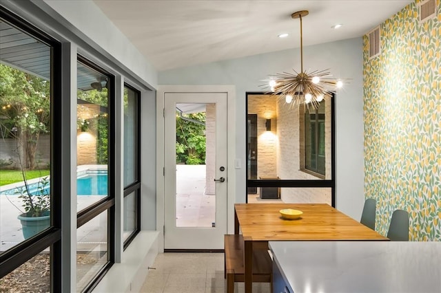 doorway to outside featuring lofted ceiling and an inviting chandelier