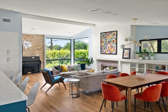 living room with vaulted ceiling, a chandelier, and light hardwood / wood-style floors