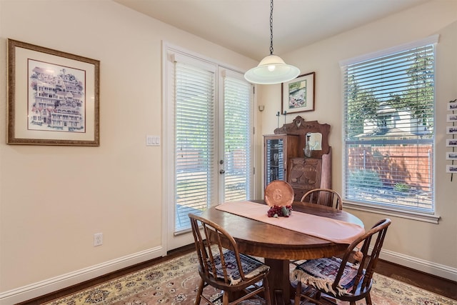 dining space with french doors, a wealth of natural light, and hardwood / wood-style flooring