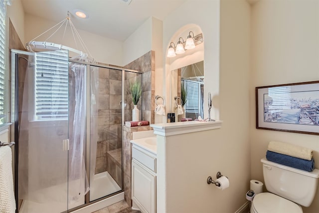 bathroom with toilet, walk in shower, and vanity