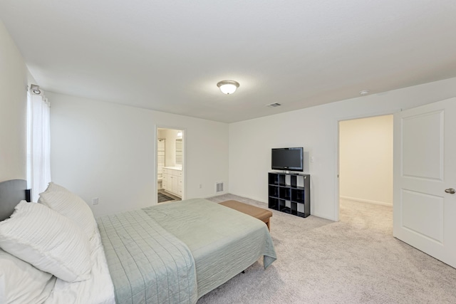 bedroom with light colored carpet and connected bathroom