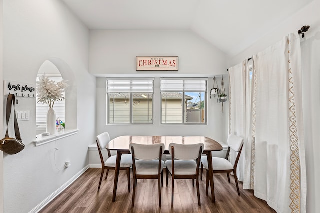 dining space featuring breakfast area, dark hardwood / wood-style flooring, and lofted ceiling