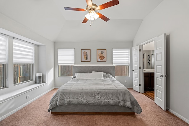 bedroom featuring lofted ceiling, ceiling fan, carpet, multiple windows, and connected bathroom