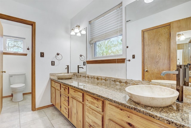 bathroom featuring tile patterned flooring, vanity, and toilet