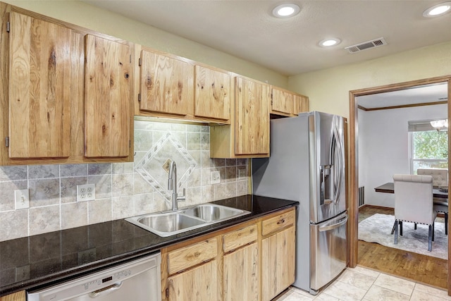 kitchen with dishwashing machine, sink, stainless steel refrigerator with ice dispenser, tasteful backsplash, and light brown cabinets