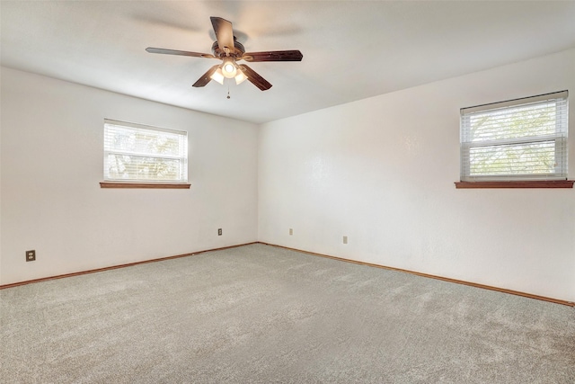 carpeted empty room featuring ceiling fan and a healthy amount of sunlight