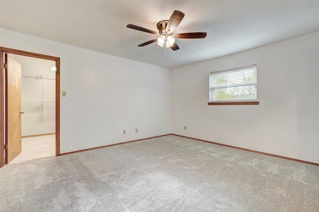 unfurnished room with ceiling fan and light carpet