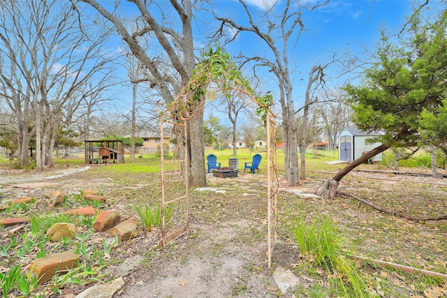 view of yard featuring a storage unit and a fire pit