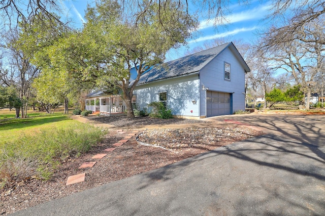 view of side of home featuring a porch and a garage