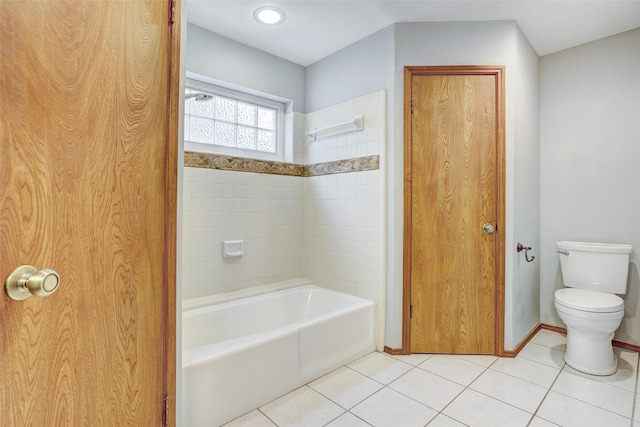 bathroom featuring tile patterned flooring, tiled shower / bath, and toilet