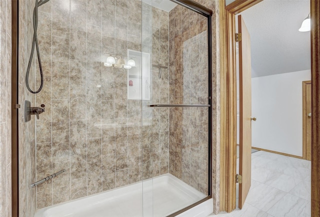 bathroom featuring a shower with shower door and a textured ceiling