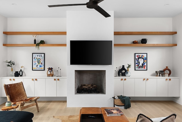 living room with light wood-type flooring and ceiling fan