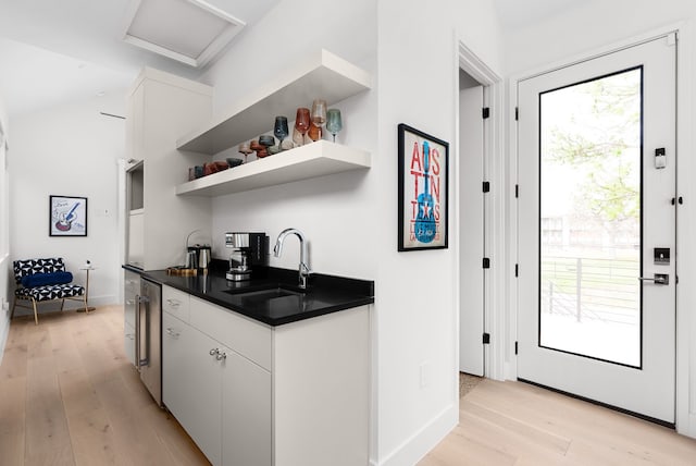 kitchen featuring light wood-type flooring, white cabinets, and sink