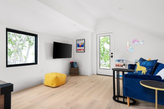 sitting room featuring light wood-type flooring and vaulted ceiling