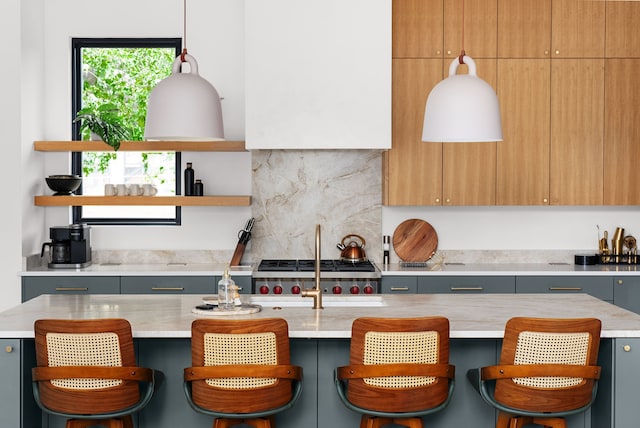 kitchen with a breakfast bar, gray cabinets, and a kitchen island