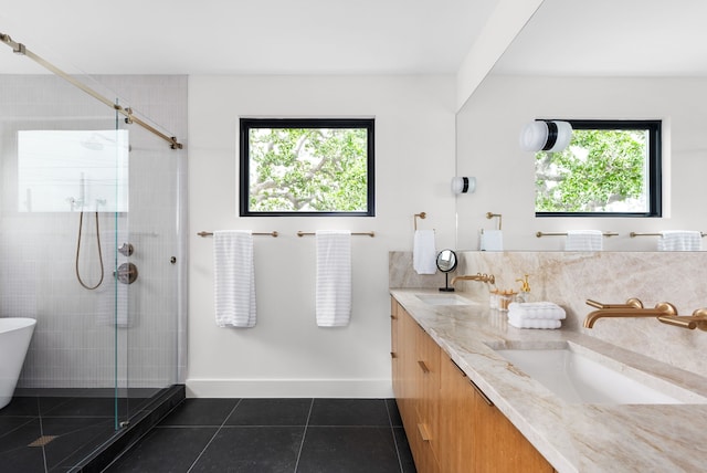 bathroom with plus walk in shower, tile patterned flooring, plenty of natural light, and vanity