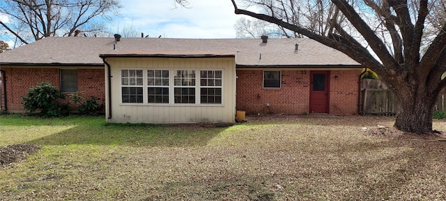 rear view of property featuring a yard