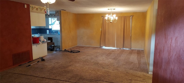 interior space with ceiling fan with notable chandelier, a textured ceiling, and carpet flooring