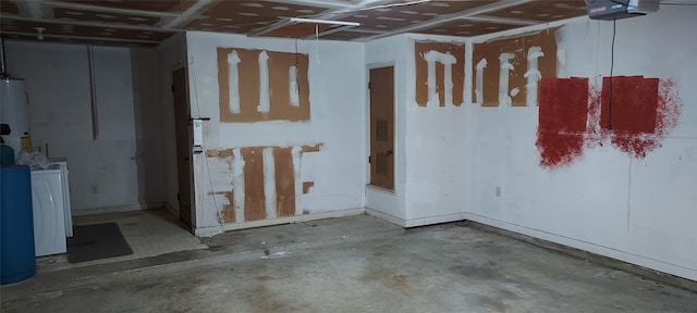 basement featuring water heater and washer / dryer