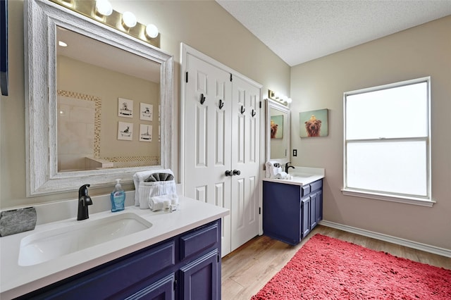 bathroom featuring a textured ceiling, a shower, hardwood / wood-style flooring, and vanity