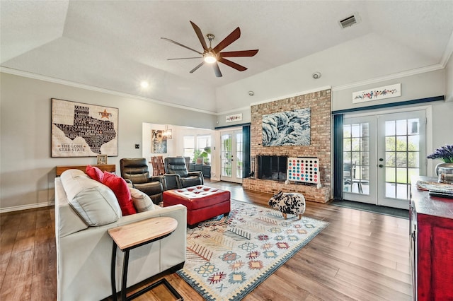 living room featuring ceiling fan, a raised ceiling, and french doors