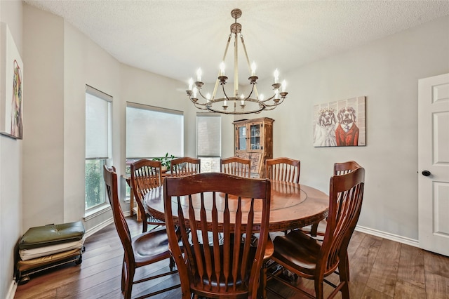 dining area featuring dark hardwood / wood-style floors, an inviting chandelier, and a textured ceiling