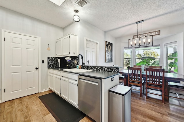 kitchen featuring white cabinetry, an inviting chandelier, sink, hanging light fixtures, and stainless steel dishwasher