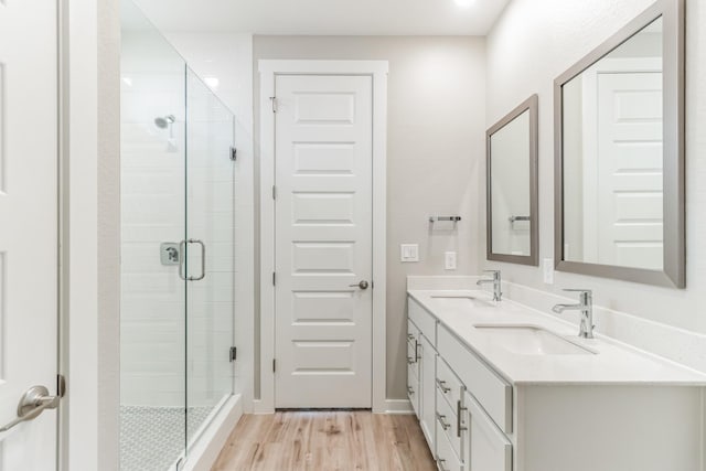 bathroom with hardwood / wood-style floors, an enclosed shower, and vanity