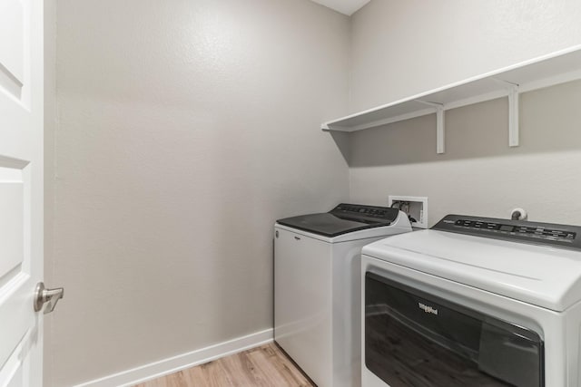 washroom featuring washer and dryer and light hardwood / wood-style flooring