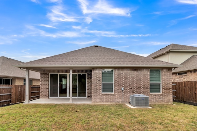 rear view of house featuring cooling unit, a patio area, and a yard