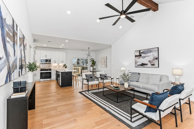 living room featuring ceiling fan, light hardwood / wood-style flooring, beam ceiling, and high vaulted ceiling