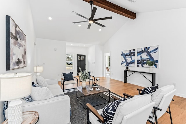 living room featuring ceiling fan, vaulted ceiling with beams, and wood-type flooring