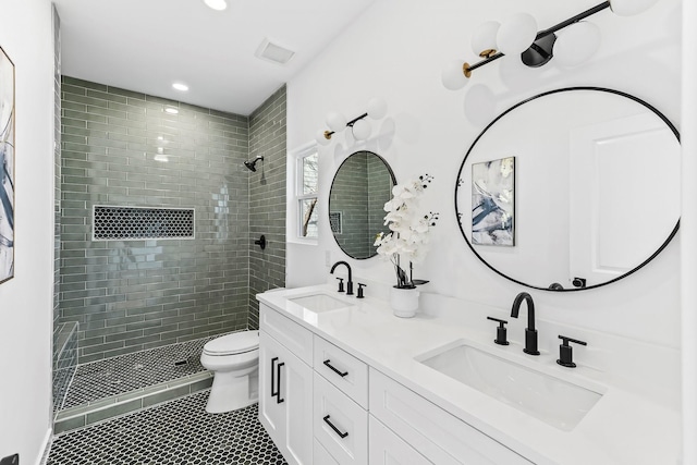 bathroom featuring vanity, toilet, and tiled shower