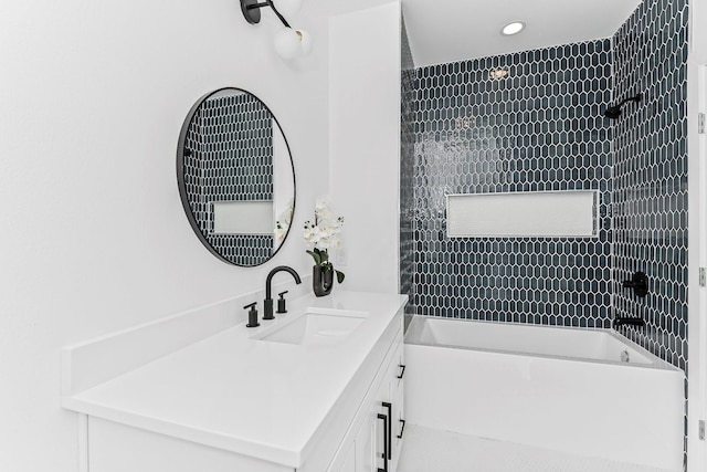 bathroom featuring tiled shower / bath and vanity