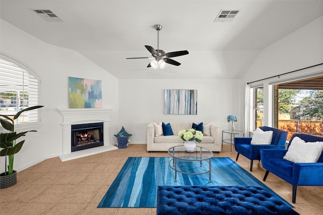 living room featuring light tile patterned floors, vaulted ceiling, and plenty of natural light