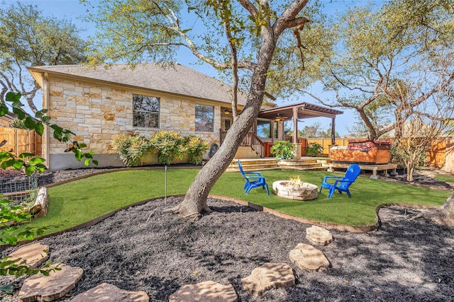 view of yard featuring a hot tub and an outdoor fire pit