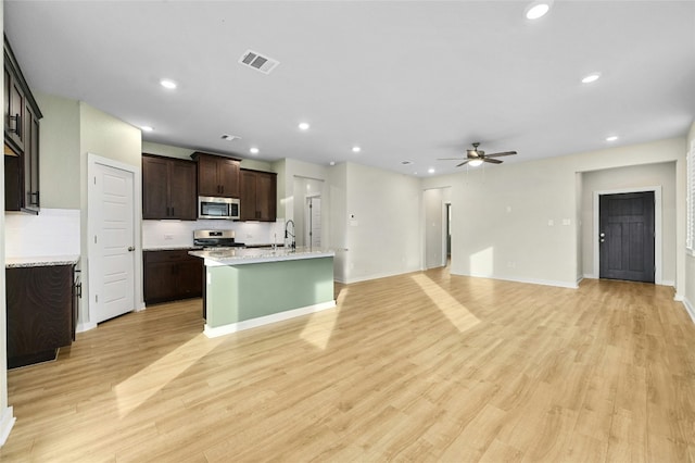 107 Dedina Dr, Georgetown, TX 78626 - kitchen featuring appliances with stainless steel finishes, ceiling fan, light countertops, dark brown cabinets, and light wood-style floors