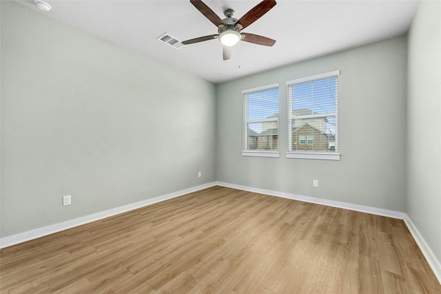 spare room featuring a ceiling fan, light wood-style flooring, baseboards, and visible vents