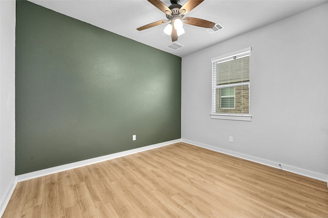 empty room with ceiling fan, light wood-style flooring, visible vents, and baseboards