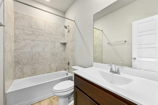 bathroom with vanity, wood finished floors, shower / tub combination, and toilet
