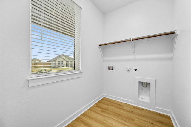 clothes washing area with wood finished floors, baseboards, laundry area, electric dryer hookup, and hookup for a gas dryer