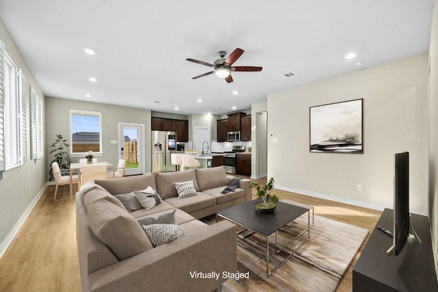 living room featuring visible vents, recessed lighting, baseboards, and light wood-style floors