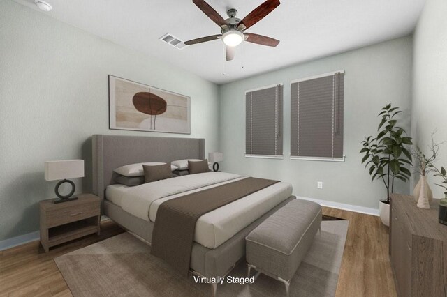 bedroom featuring a ceiling fan, visible vents, baseboards, and wood finished floors