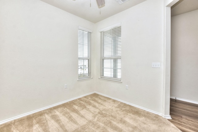 carpeted spare room with ceiling fan and a healthy amount of sunlight