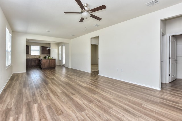 unfurnished living room featuring ceiling fan and hardwood / wood-style floors